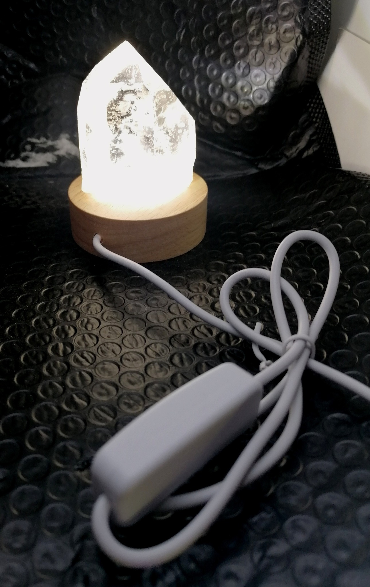 Křišťálová špice na bílém svítícím podstavci – dekorace i energetický kámen